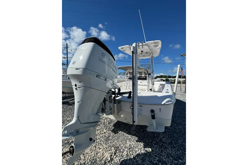 Slide: The Image of 2022 Aquasport 230 Pro Bay boat with Suzuki outboard motor, parked on gravel. - 7