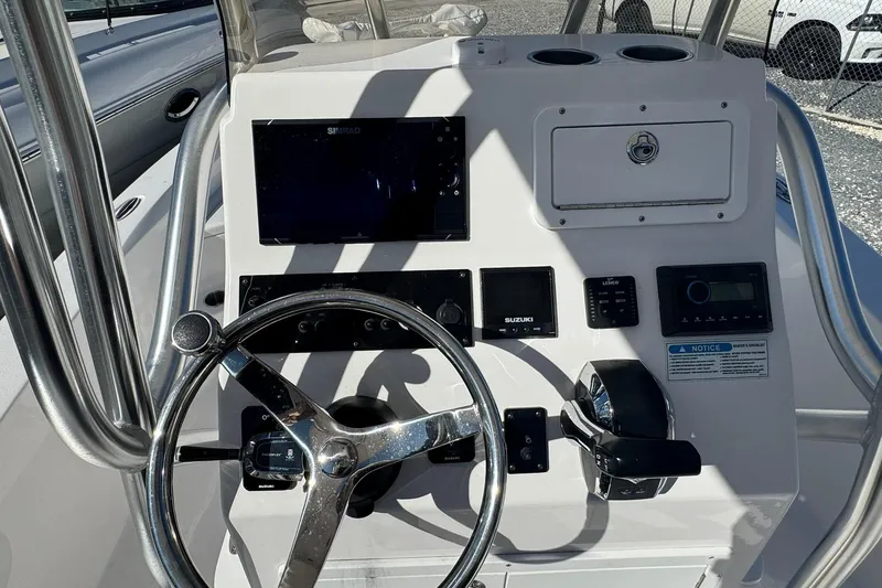 Slide: The Image of 2022 Aquasport 230 Pro Bay boat dashboard with steering wheel and control panel. - 9