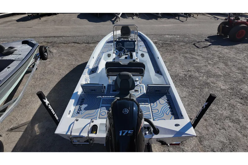 Slide: The Image of 2026 Xpress H22B Bay boat with Yamaha 175 engine, parked on gravel. - 12