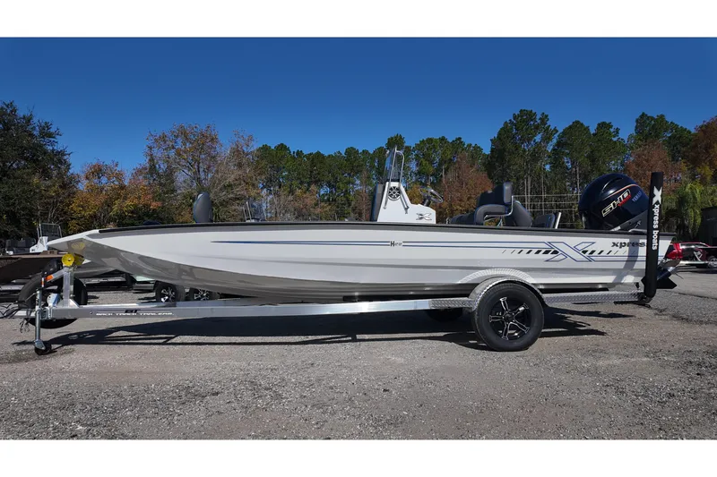 Slide: The Image of 2026 Xpress H22B Bay boat on trailer, parked outdoors under clear blue sky. - 2
