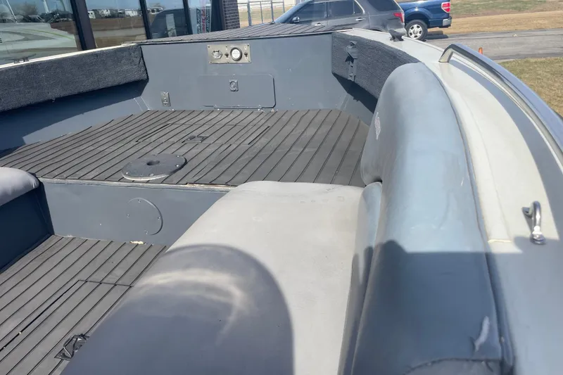 Slide: The Image of 1997 Lowe Classic 257 boat interior with gray seating and deck, parked outdoors. - 5