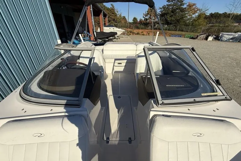 Slide: The Image of 2006 Regal 2000 boat with open cockpit and seating, parked outdoors. - 26