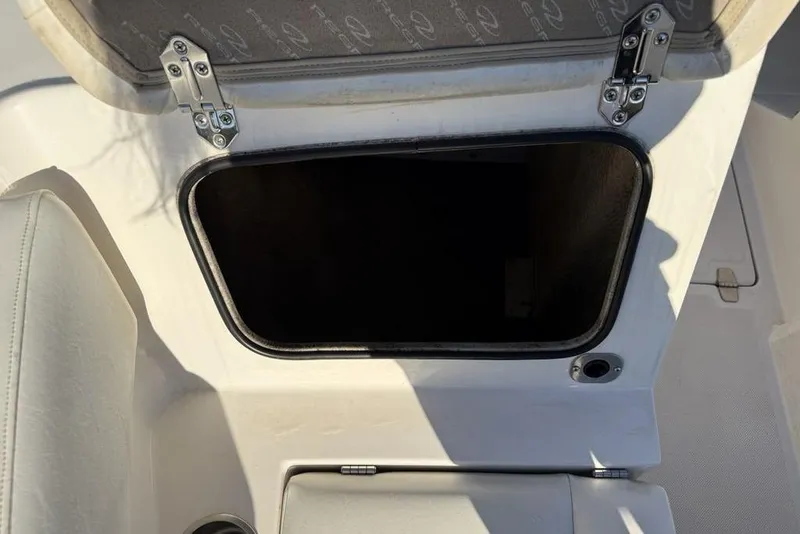 Slide: The Image of Open storage compartment on a 2006 Regal 2000 boat, featuring secure hinges. - 6