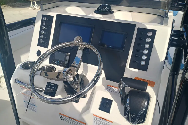 Slide: The Image of 2026 Robalo R222 Center Console boat dashboard with steering wheel and control panel. - 15