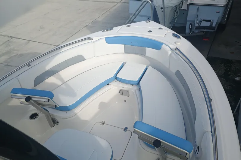 Slide: The Image of 2026 Robalo R222 Center Console boat with blue and white seating in a marina. - 17