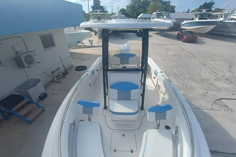Slide: The Image of 2026 Robalo R222 Center Console boat with blue and white seating, docked outdoors. - 19