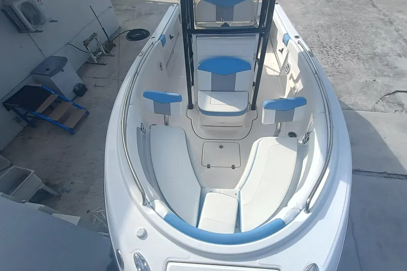 Slide: The Image of 2026 Robalo R222 Center Console boat interior with blue and white seating, docked outdoors. - 20