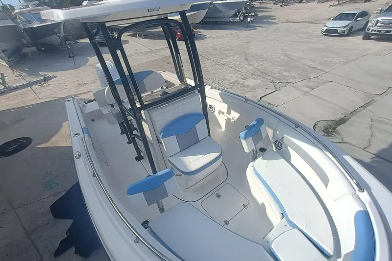 Slide: The Image of 2026 Robalo R222 Center Console boat with blue and white seating, docked outdoors. - 21