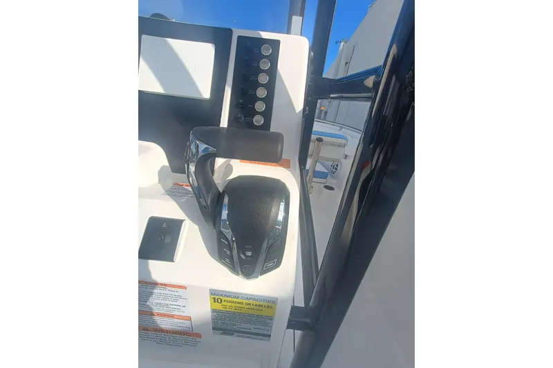 Slide: The Image of 2026 Robalo R222 Center Console boat dashboard with controls and capacity label. - 34