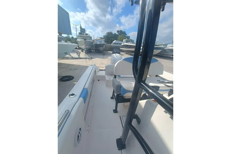 Slide: The Image of 2026 Robalo R222 Center Console boat interior with seating, docked under a cloudy sky. - 35