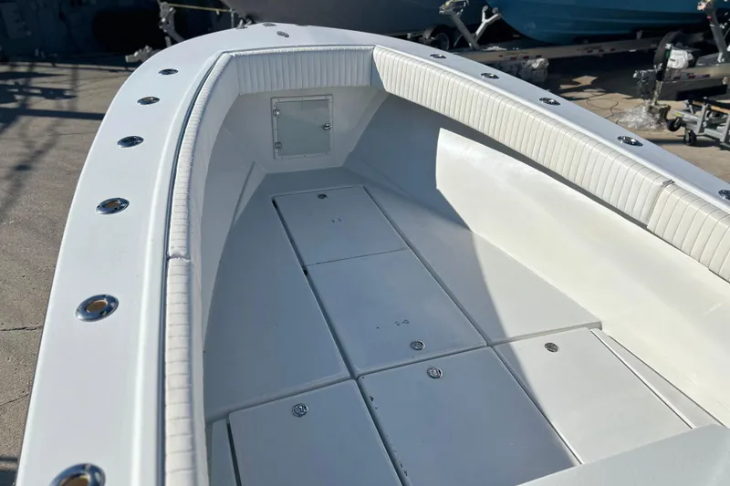 Slide: The Image of 1991 Contender 25 Open boat interior with white seating and storage compartments. - 16