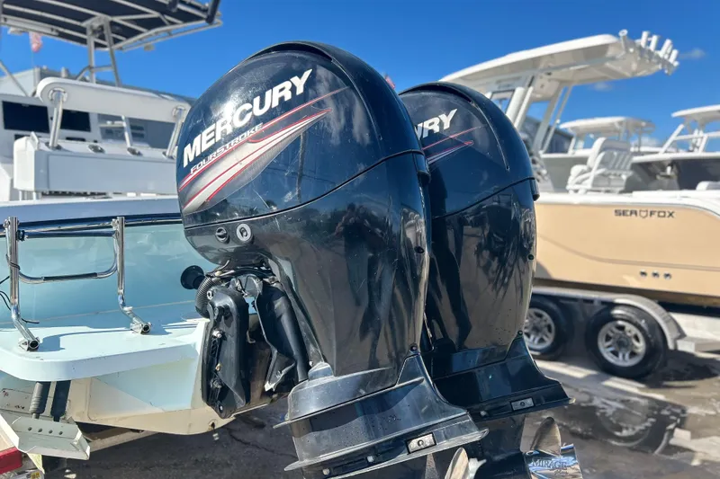 Slide: The Image of Twin Mercury outboard engines on a 1991 Contender 25 Open boat, docked with other vessels. - 3