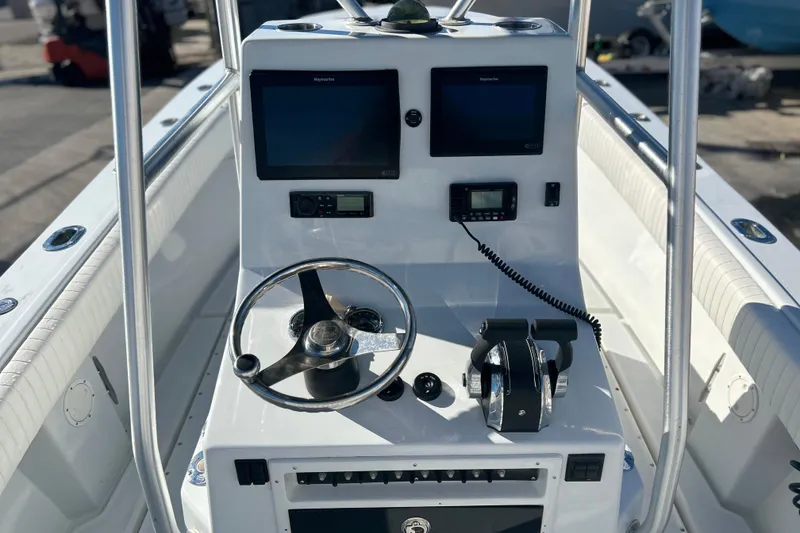 Slide: The Image of 1991 Contender 25 Open boat console with steering wheel, dual screens, and controls. - 5