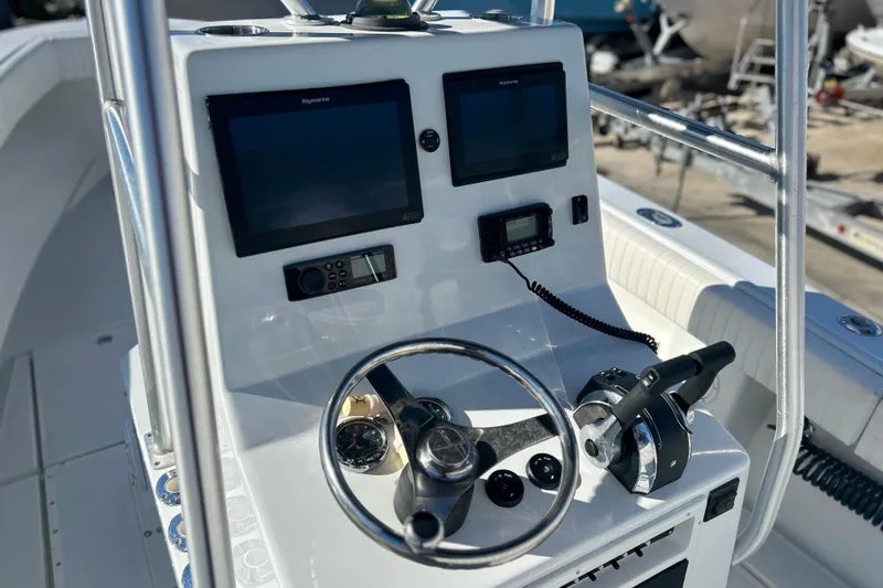 Slide: The Image of 1991 Contender 25 Open boat console with steering wheel, dual screens, and control panel. - 7