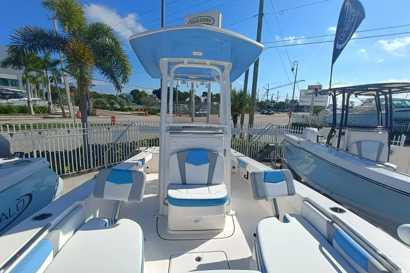 Slide: The Image of 2026 Robalo 226 Cayman boat with blue and white seating, displayed outdoors. - 16
