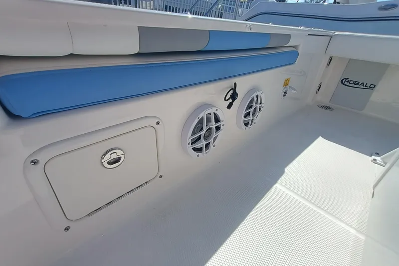 Slide: The Image of 2026 Robalo 226 Cayman boat interior with blue seating and speaker system. - 25