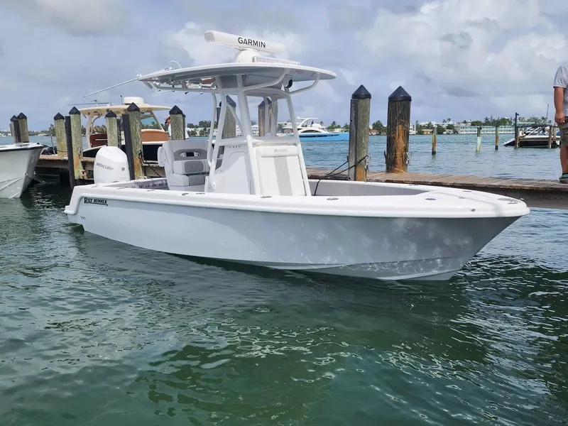 The Image of 2026 Reef Runner 230 boat cruising on open water under clear blue skies. - 0