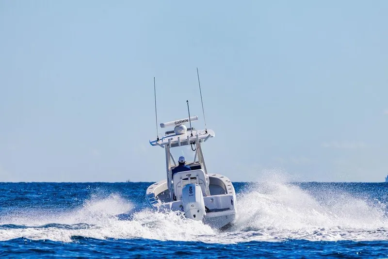 Slide: The Image of 2026 Reef Runner 230 boat dashboard with dual screens, steering wheel, and ocean view. - 22
