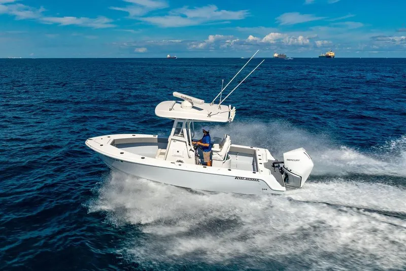 Slide: The Image of Control panel of 2026 Reef Runner 230 boat with steering wheel and digital displays. - 23
