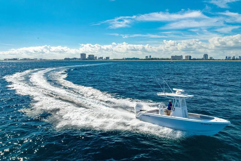 Slide: The Image of Helm of 2026 Reef Runner 230 boat with dual navigation screens and steering wheel. - 24