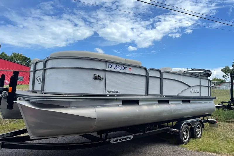 The Image of 2017 Manitou 22 Aurora LE Standard pontoon boat on trailer under blue sky. - 1