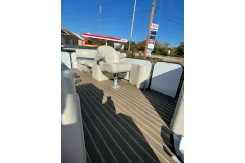 Slide: The Image of 2017 Manitou 22 Aurora LE Standard pontoon boat with beige seating and striped deck. - 10