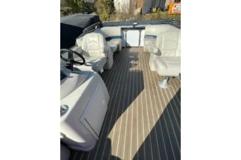 Slide: The Image of 2017 Manitou 22 Aurora LE Standard pontoon boat interior with seating and steering console. - 7