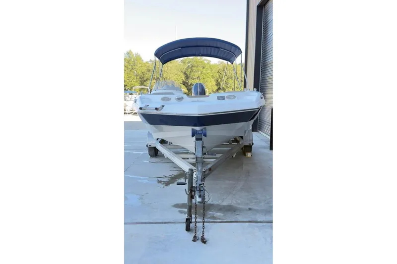 Slide: The Image of 2013 NauticStar 203 SC boat on trailer with blue canopy in storage area. - 3