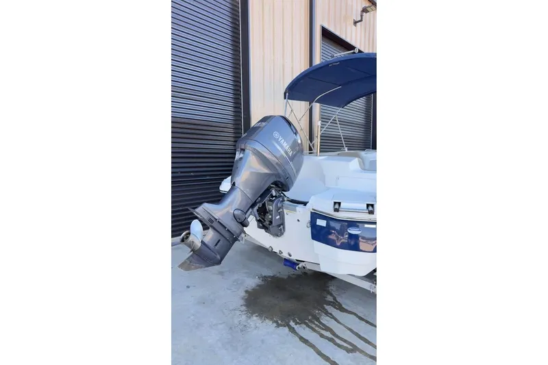 Slide: The Image of 2013 NauticStar 203 SC boat with Yamaha outboard motor, parked near a building. - 5