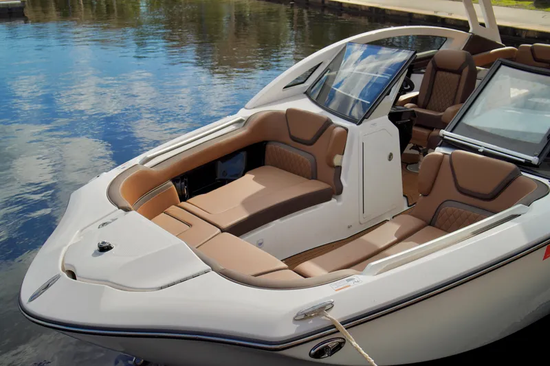 Slide: The Image of 2025 Yamaha Boats 275SD with luxurious seating on calm water. - 11