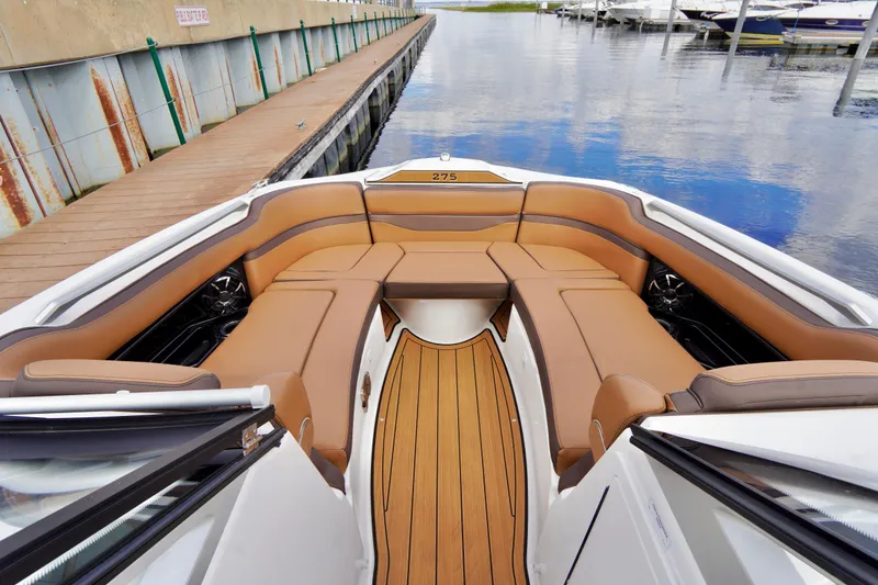 Slide: The Image of Luxurious interior of 2025 Yamaha Boats 275SD with tan seating and wooden flooring. - 12