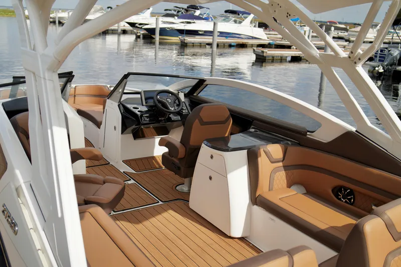 Slide: The Image of 2025 Yamaha Boats 275SD interior with luxurious seating and modern dashboard, docked at marina. - 25