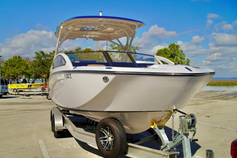 Slide: The Image of 2025 Yamaha Boats 275SD on trailer, parked outdoors under a clear blue sky. - 3