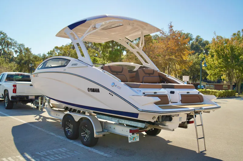 Slide: The Image of 2025 Yamaha Boats 275SD on trailer, parked outdoors, showcasing sleek design and modern features. - 32