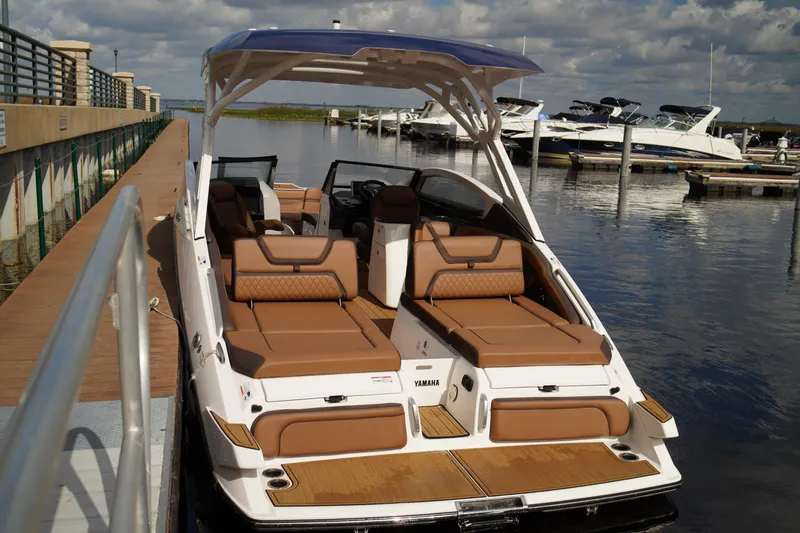 Slide: The Image of 2025 Yamaha Boats 275SD docked, featuring luxurious brown seating and sleek design. - 37