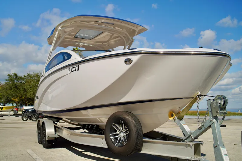Slide: The Image of 2025 Yamaha Boats 275SD on trailer, parked outdoors under a blue sky. - 4