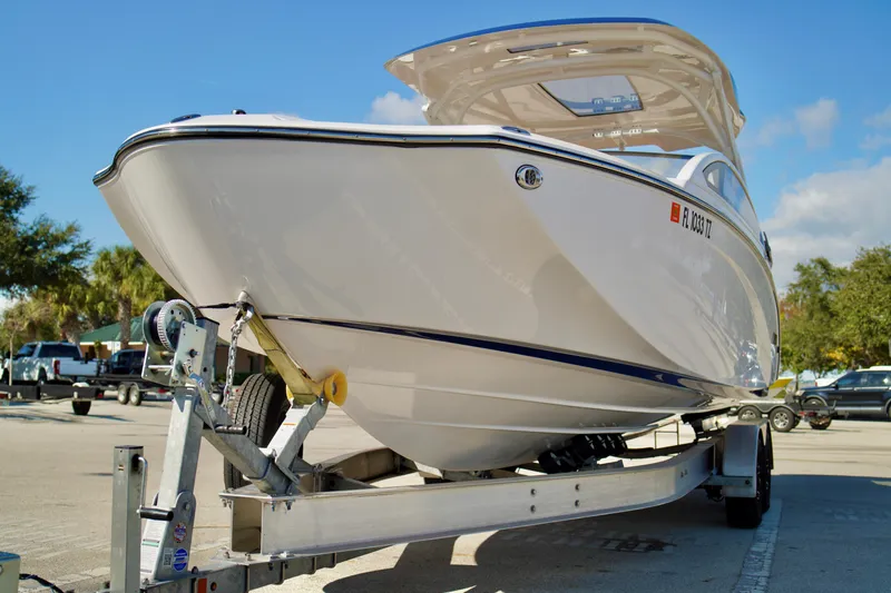 Slide: The Image of 2025 Yamaha Boats 275SD on trailer, parked outdoors under clear blue sky. - 5