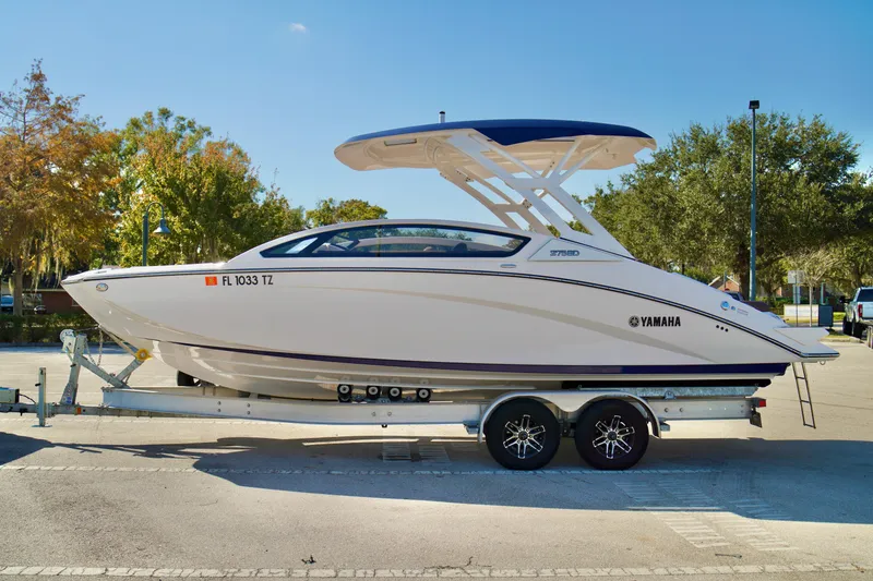 Slide: The Image of 2025 Yamaha Boats 275SD on trailer, parked outdoors, showcasing sleek design and modern features. - 8