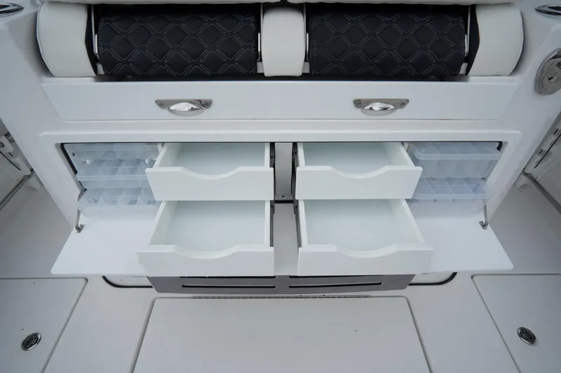 Slide: The Image of 2023 Tidewater 380 CC Adventure boat interior with seating and deck, docked near water. - 15