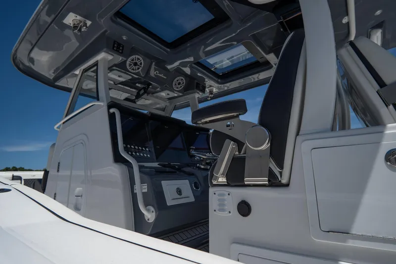 Slide: The Image of 2023 Tidewater 380 CC Adventure boat docked in a serene marina setting. - 5