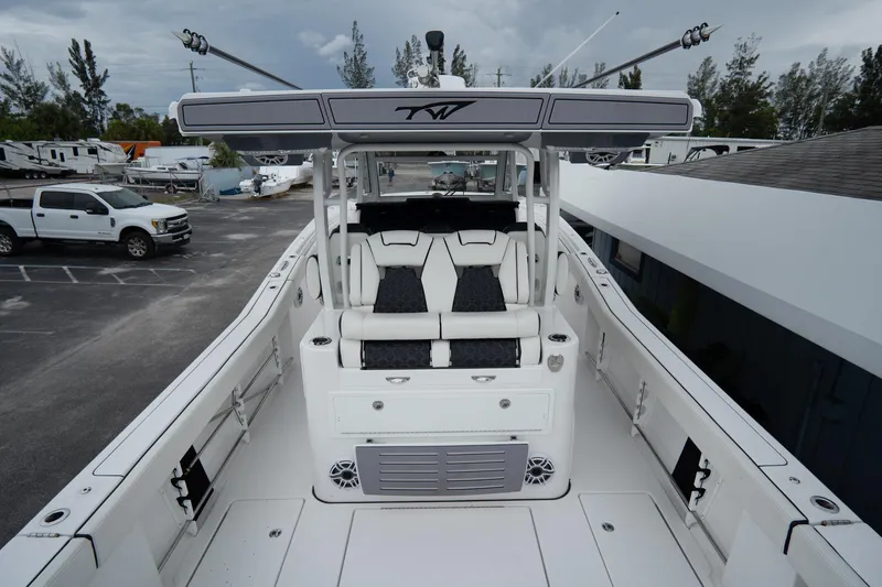 Slide: The Image of 2023 Tidewater 380 CC Adventure boat docked in a scenic waterfront setting. - 6