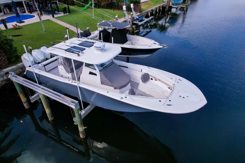 Slide: The Image of 2023 Tidewater 380 CC Adventure boat docked by waterfront home. - 80