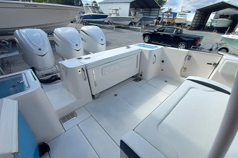 Slide: The Image of 2026 Robalo R360 Center Console boat with triple engines in a marina setting. - 10