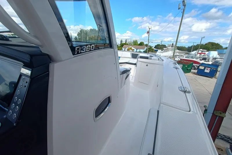 Slide: The Image of 2026 Robalo R360 Center Console boat, sleek design, docked under blue sky. - 19