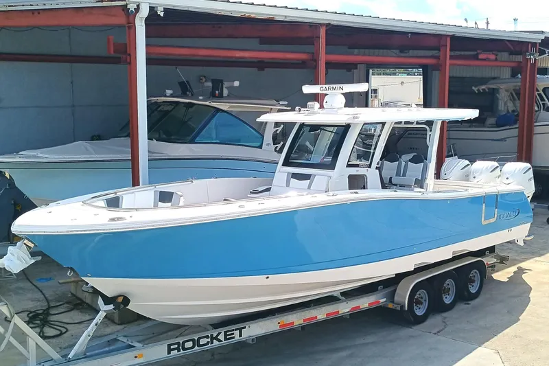 Slide: The Image of 2026 Robalo R360 Center Console boat in blue, on a trailer in a storage area. - 2