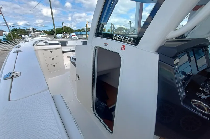 Slide: The Image of 2026 Robalo R360 Center Console boat interior with open cabin door and control panel. - 20