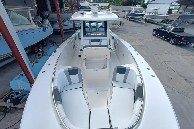 Slide: The Image of 2026 Robalo R360 Center Console boat with spacious seating and modern design in a marina. - 26