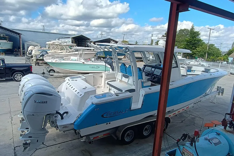 Slide: The Image of 2026 Robalo R360 Center Console boat with Yamaha engines in a marina setting. - 7