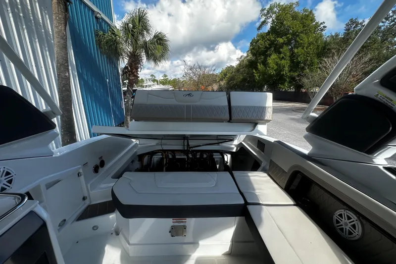 Slide: The Image of 2023 Monterey 305SS Super Sport boat interior with open engine compartment, outdoor setting. - 10