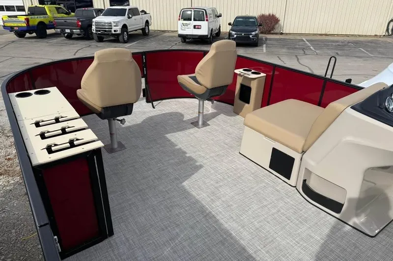 Slide: The Image of 2026 Lowe LF 214 boat interior with beige seating and red paneling in a parking lot. - 14